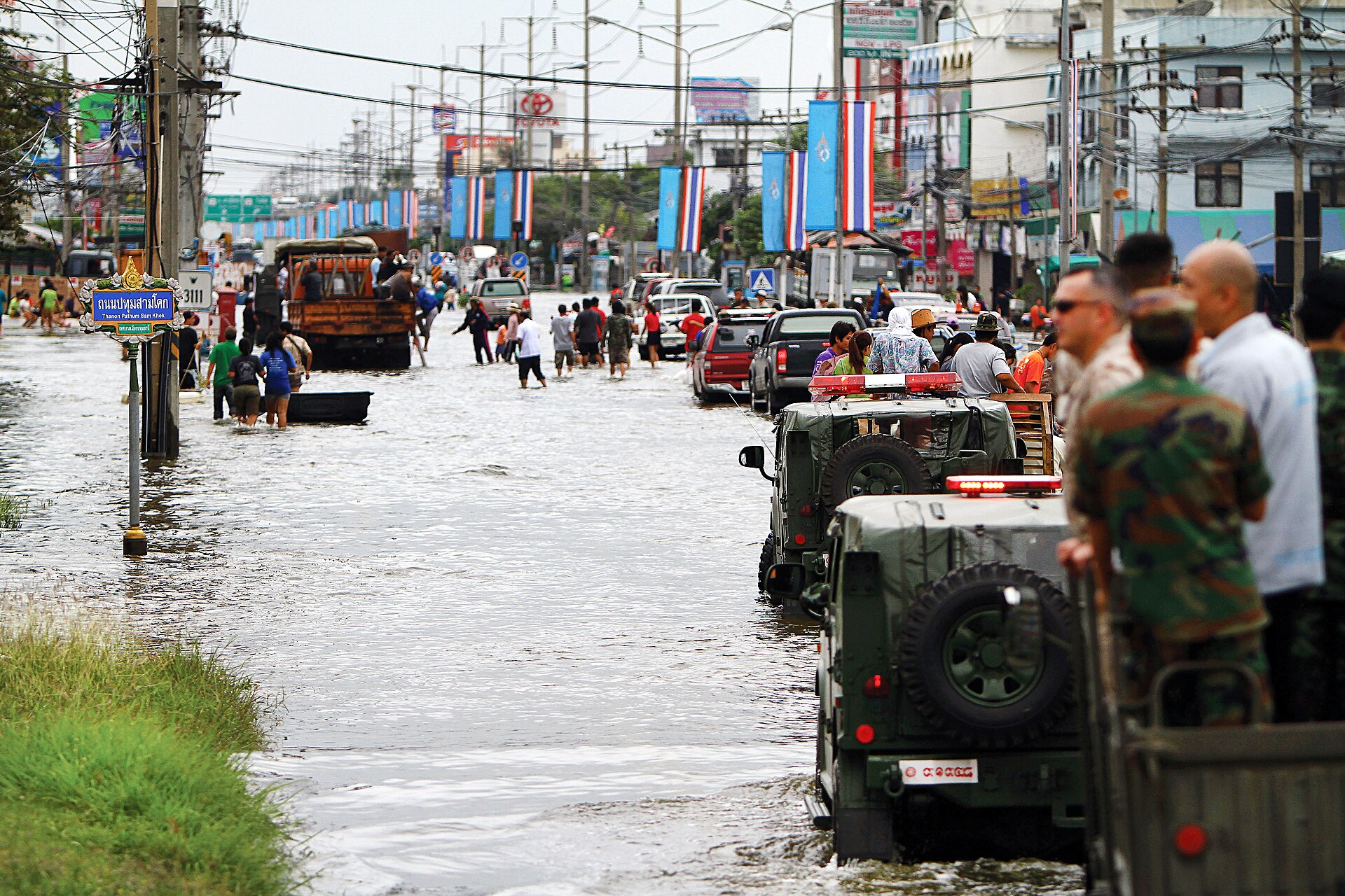 ผู้คนเดินลุยน้ำท่วมบนถนนในจังหวัดปทุมธานี ภาพจากเหตุน้ำท่วมปี 2011 (ภาพประกอบ ไม่ใช่เหตุการณ์ปัจจุบัน)