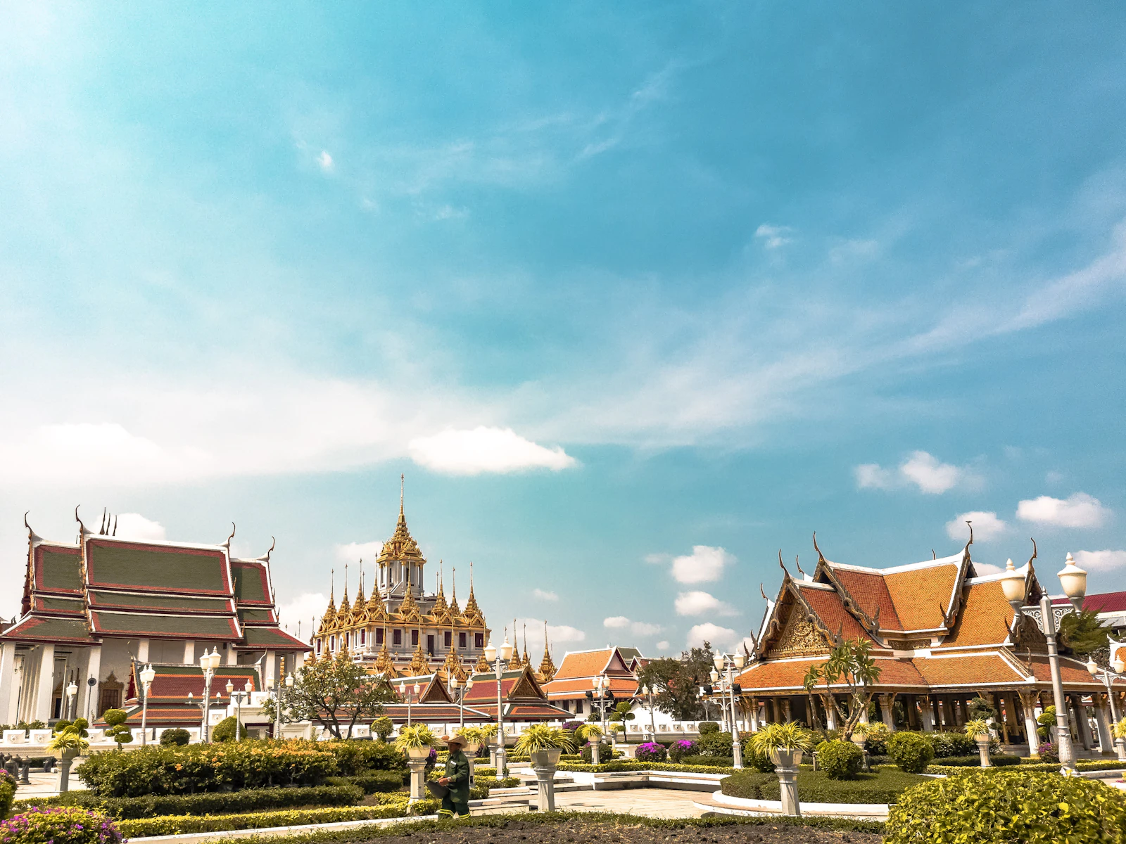 วัดและหลังคาโบสถ์สีทองในกรุงเทพฯ ใต้ท้องฟ้าสีฟ้าสดใส